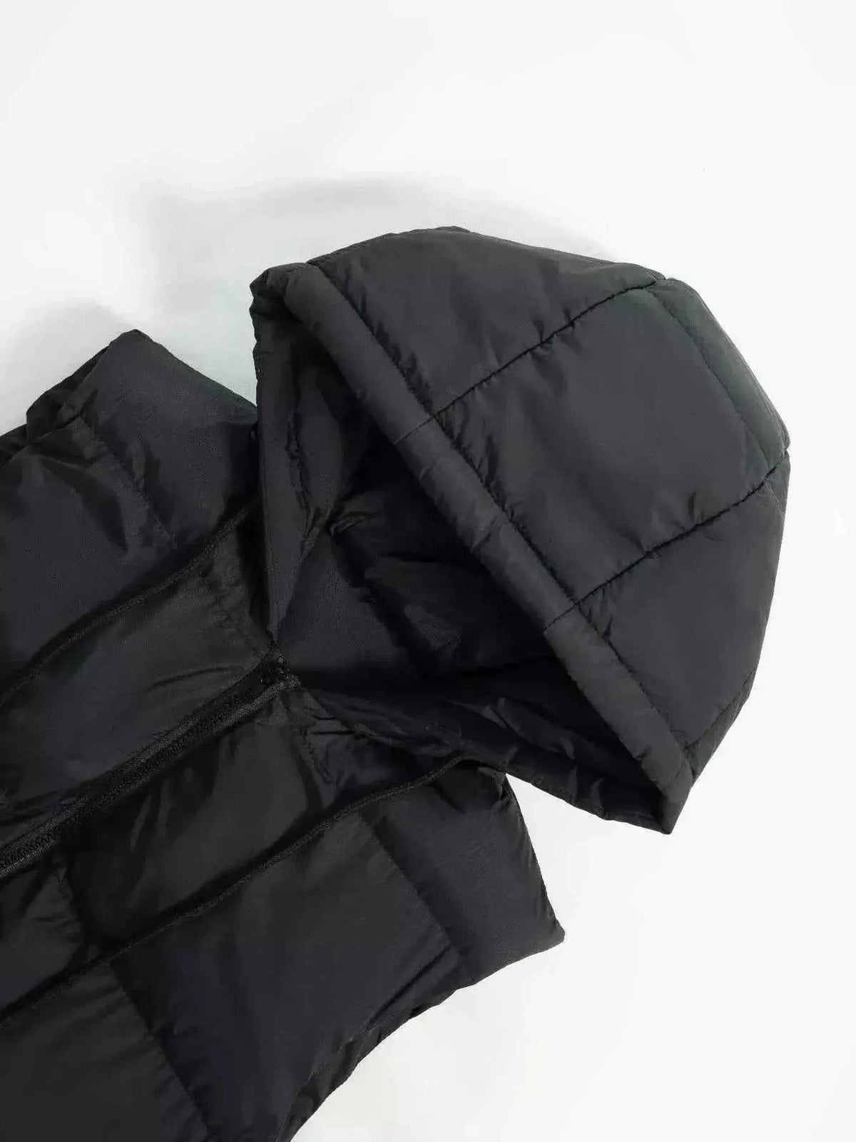 Longline Padded Hooded Vest in black polyester with quilted pattern and zipper closure detail