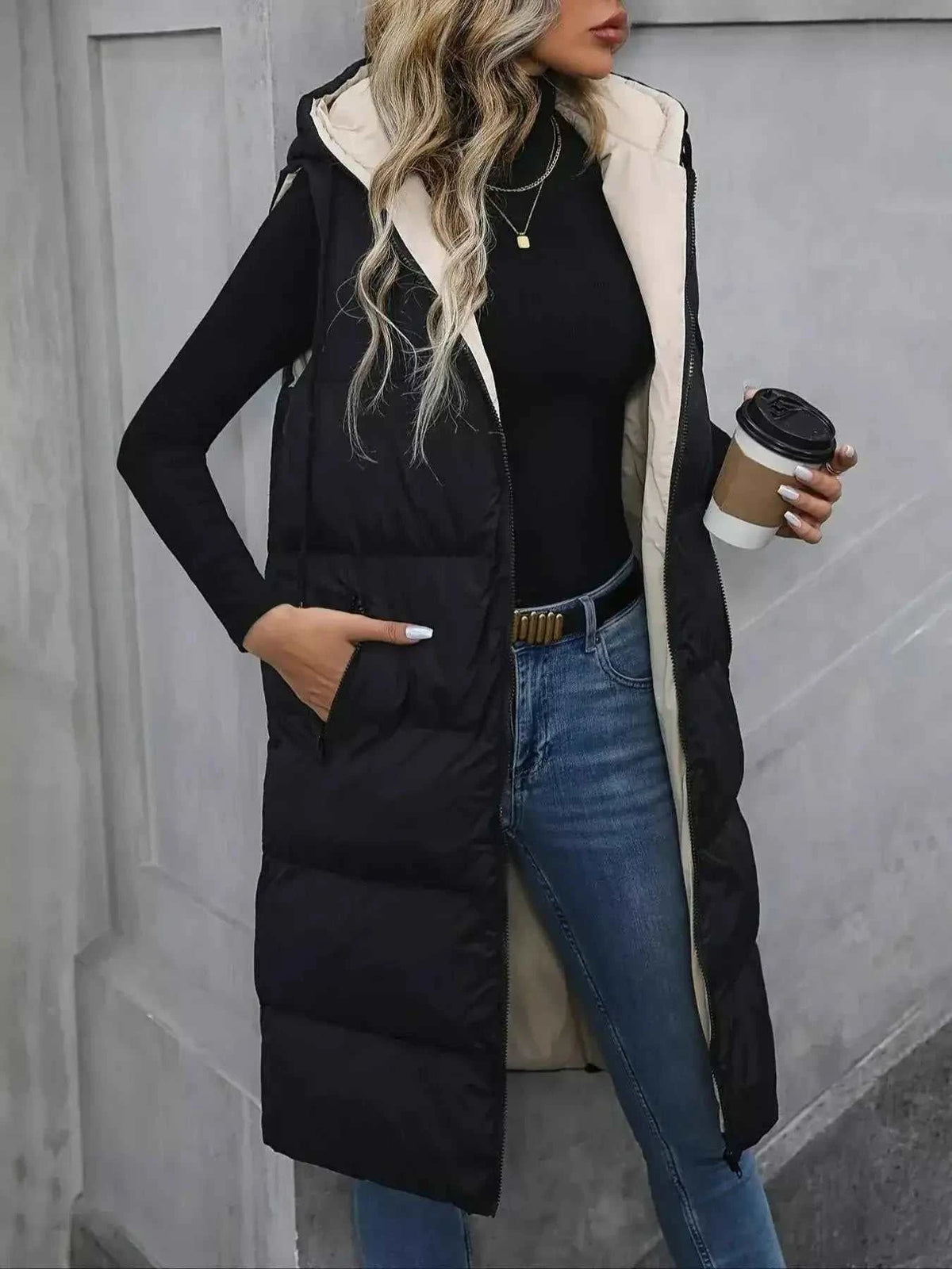 Longline Padded Hooded Vest in black with beige lining, quilted polyester material, zipper closure and side pockets