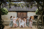 Maternity Mermaid Wedding Dress in white silk satin with strapless neckline and delicate appliques, worn by a bride with bridesmaids in pastel gowns