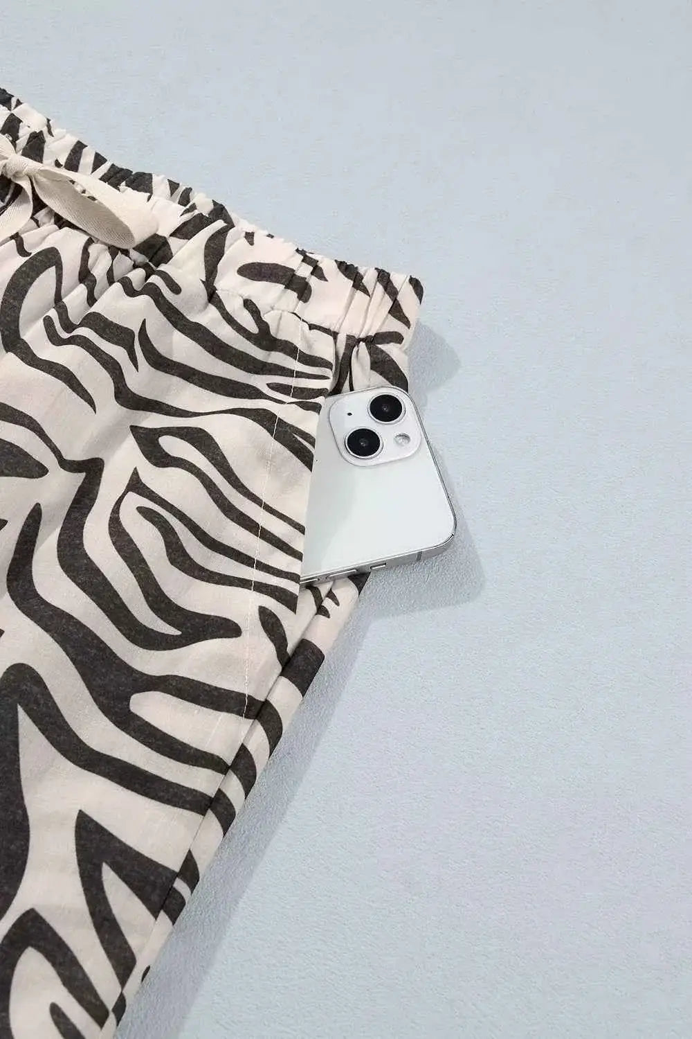 Multicolour Western Print zebra pattern elastic waist pocket pants with black and white stripes and a phone in the pocket