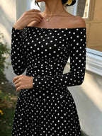 Off-the-Shoulder Maxi Dress in black with white polka dots, featuring a fitted bodice and long sleeves with an off-shoulder neckline.