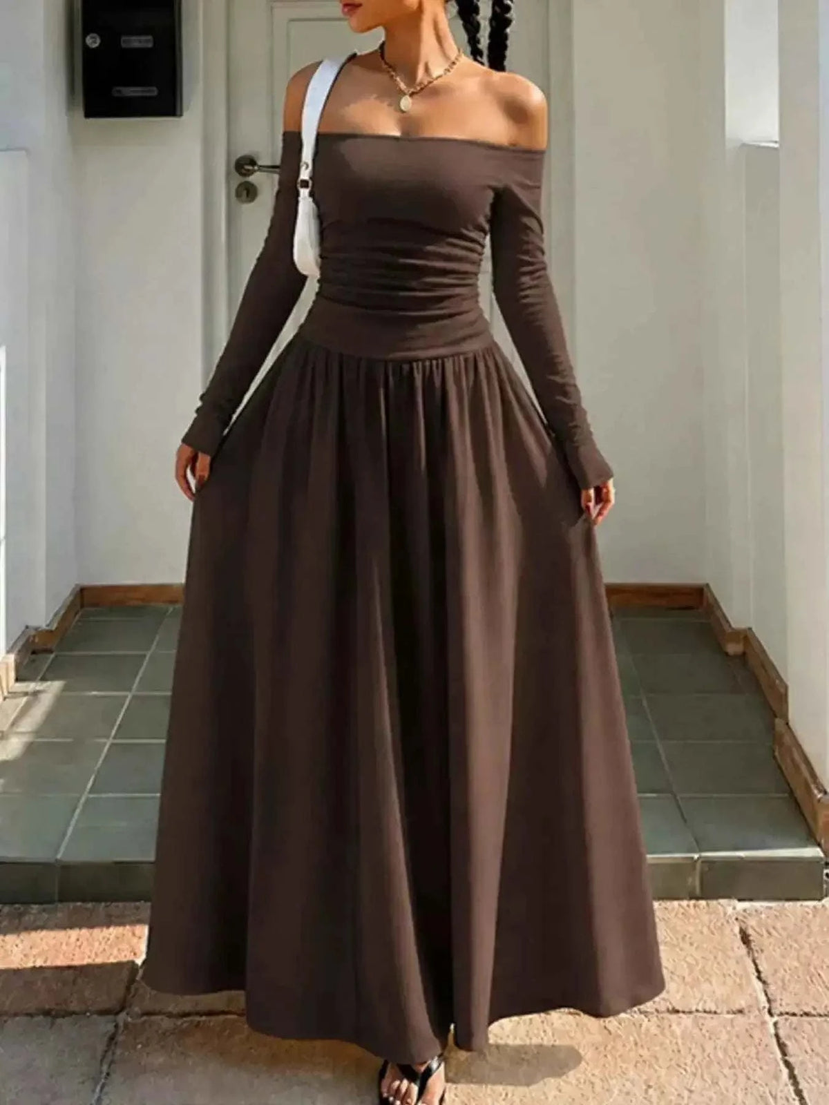 Off-the-Shoulder Maxi Dress in dark brown with long sleeves, fitted bodice, and flowing floor-length skirt made from lightweight fabric.