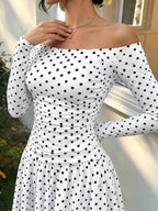 Off-the-Shoulder Maxi Dress in white fabric with black polka dots, featuring long sleeves and a fitted ruched bodice.