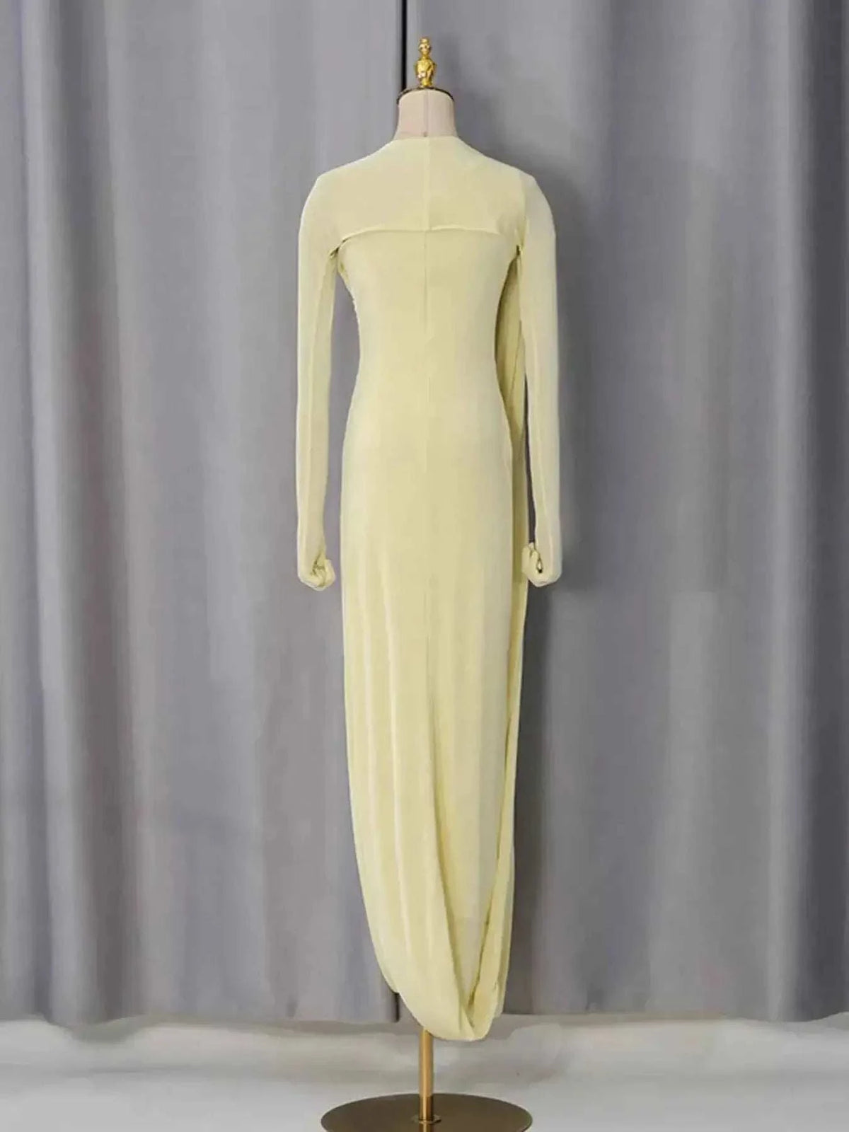 Long-sleeve pale yellow floor-length gown with a high neckline and form-fitting silhouette, One-Shoulder Draped Maxi Dress appears different than described.