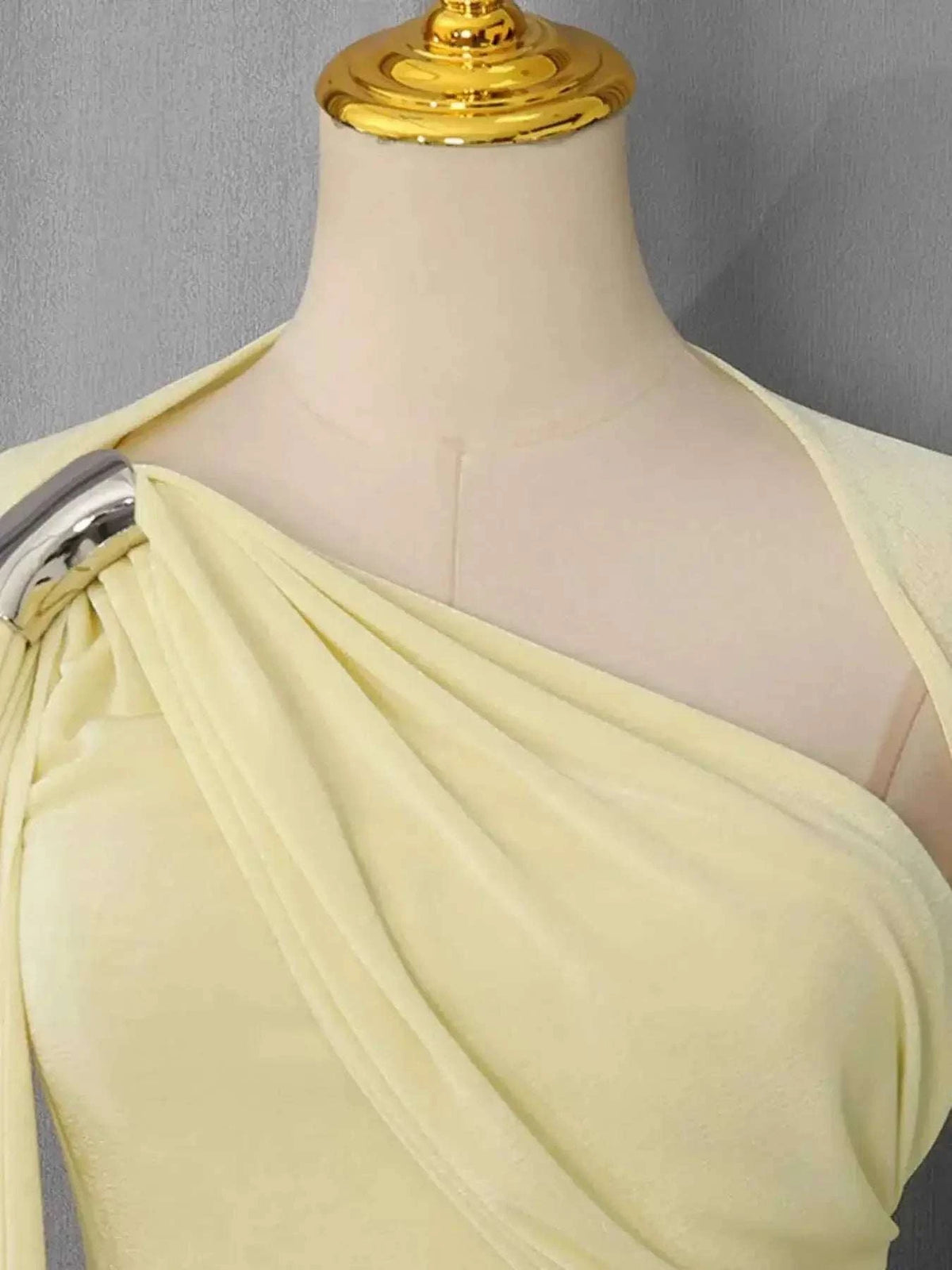 One-Shoulder Draped Maxi Dress in pale yellow polyester with asymmetric neckline and soft ruching detailing on a mannequin bust