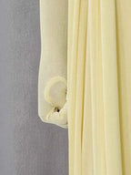 One-Shoulder Draped Maxi Dress in soft pale yellow fabric with ruched texture and flowing pleated details
