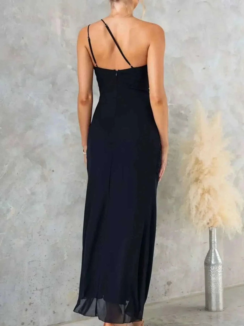 Black polyester One-Shoulder Ruffle Slit Dress with thin straps and a back zipper, featuring a slightly stretchy fit.