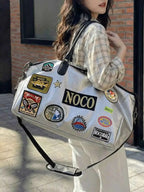 Patchwork Embellished Travel Bag in silver PU leather with black handles, decorated with colorful patches and badges