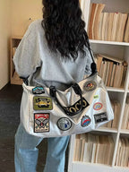 Large silver PU leather Patchwork Embellished Travel Bag with multiple colorful patches worn over shoulder
