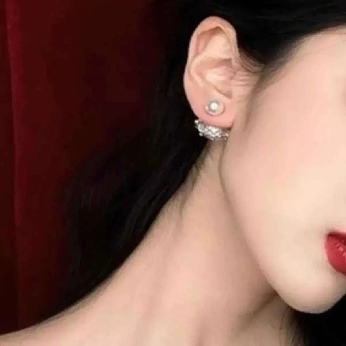 Pearl Stud Earring with synthetic white pearl and 925 silver needle on a woman's ear with smooth skin and dark hair