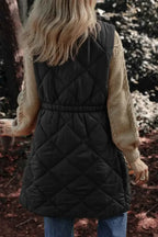 Pocketed Zipper and Button Vest in black quilted polyester with a cinched elastic waist, worn over a beige knit sweater