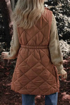 Pocketed Zipper and Button Vest in quilted rust orange polyester with an elastic waist and side pockets worn over a beige sweater