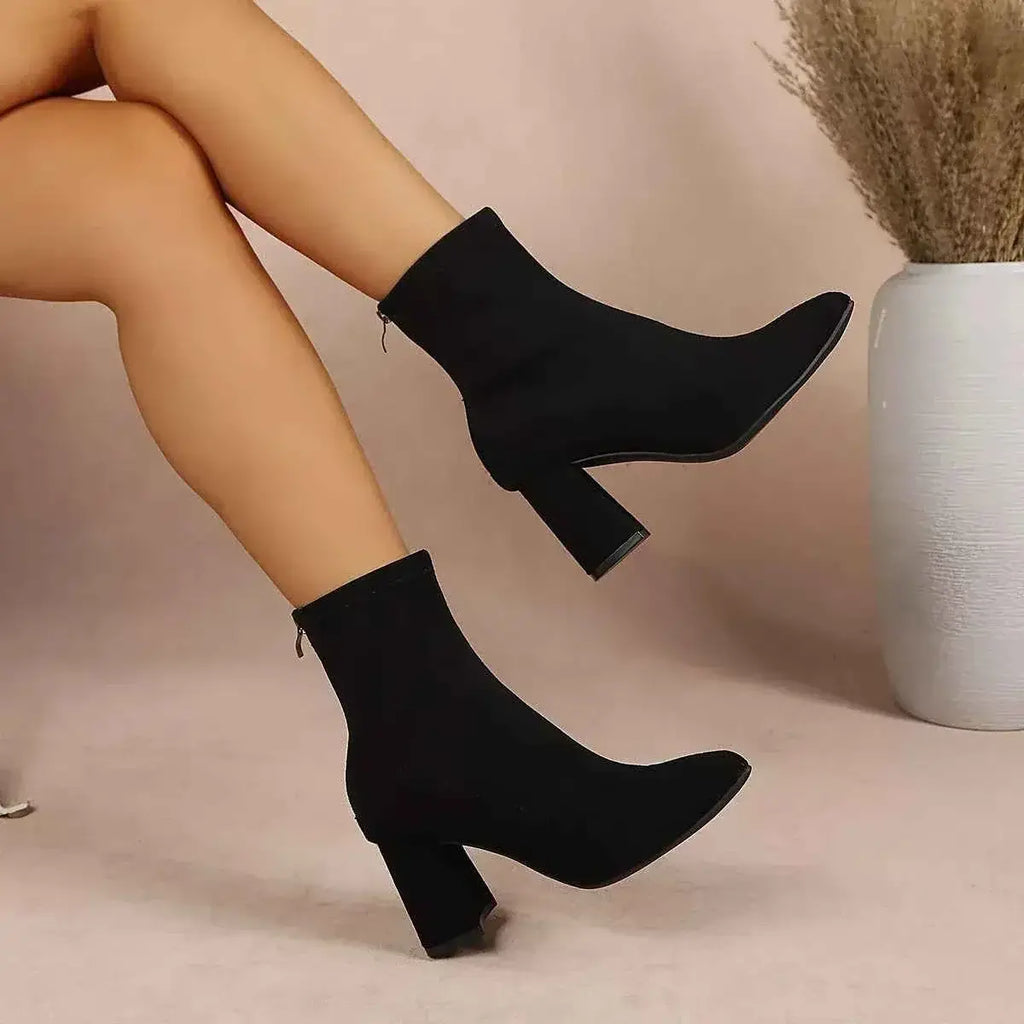 Black suede Point Toe Block Heel ankle boots with mid-height block heels and side zippers worn by a model