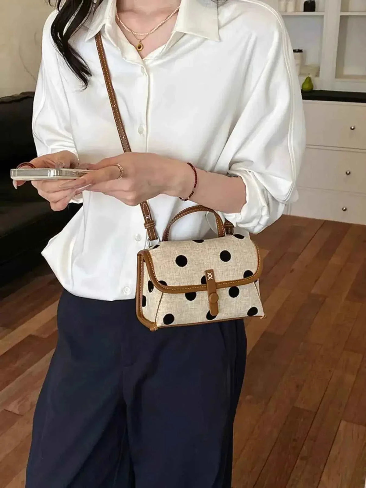 Polka Dot Crossbody Bag in beige polyester with black polka dots and brown strap, small size worn on shoulder