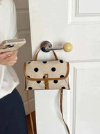 Polka Dot Crossbody Bag in beige polyester with black polka dots, brown trim, small size and adjustable strap