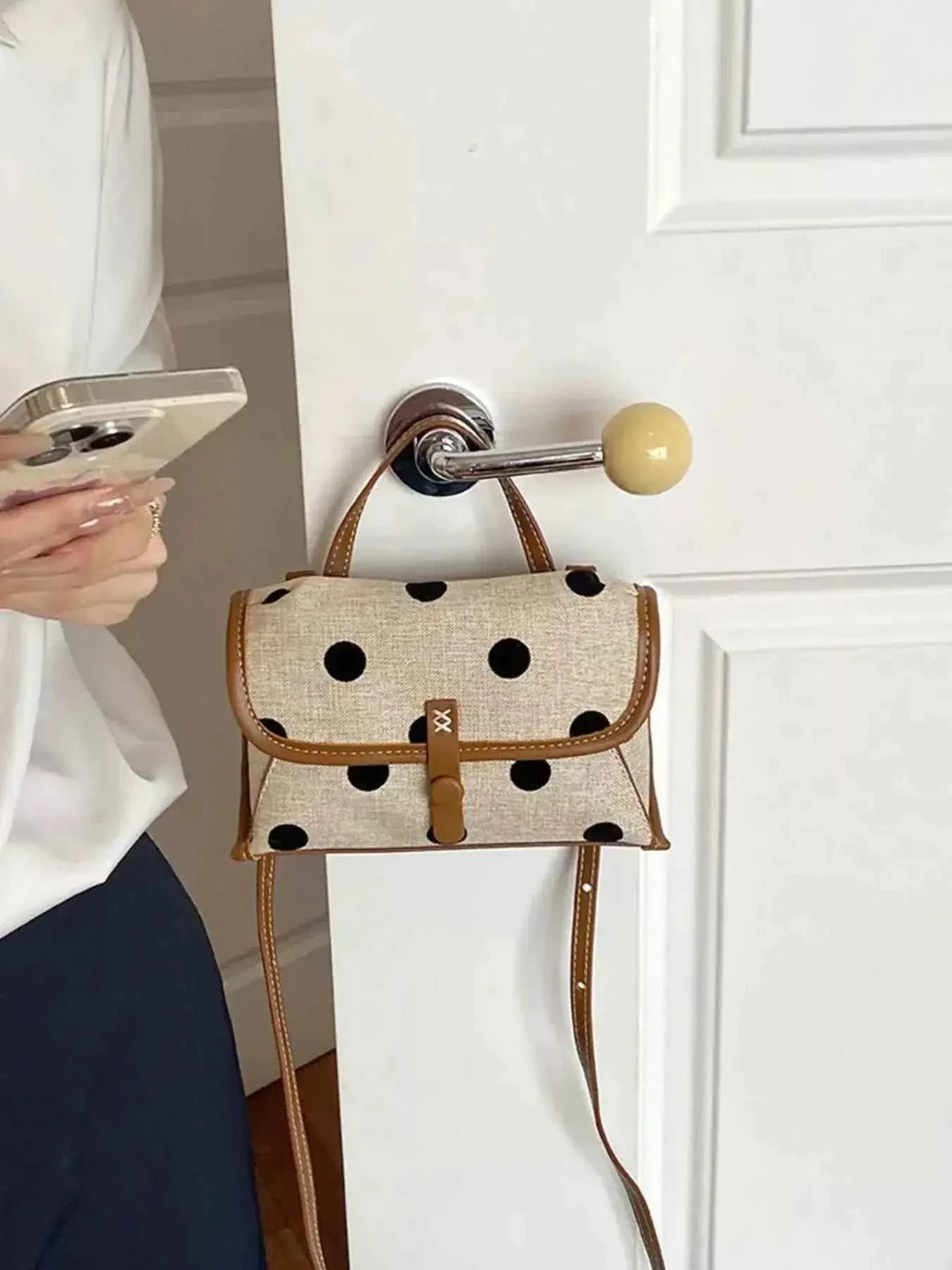 Polka Dot Crossbody Bag in beige polyester with black polka dots, brown trim, small size and adjustable strap