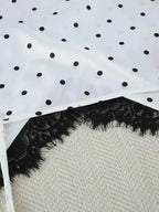 Polka Dot Lace Trim white fabric with black polka dots and delicate black lace trim detail