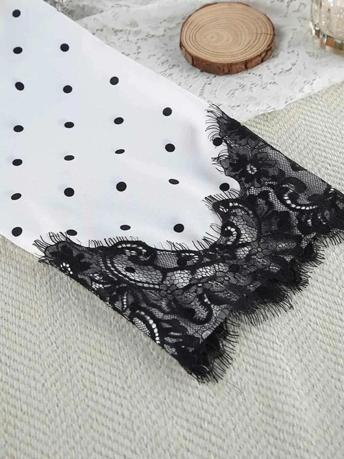 Polka Dot Lace Trim cami sleeve edge with black lace trim on white fabric featuring black polka dots, delicate floral lace detail