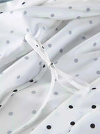White fabric with black and gray polka dots featuring delicate tied ribbon detail showcasing Polka Dot Lace Trim design