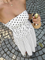 Polka Dot Ruched strapless maxi dress in white with black polka dots, featuring a fitted ruched bodice and flowy skirt