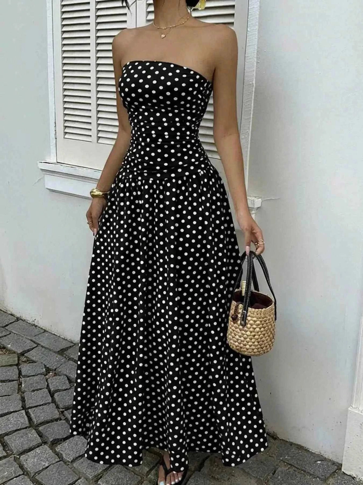 Polka Dot Ruched black strapless maxi dress with white polka dots and a fitted ruched bodice, flowing skirt
