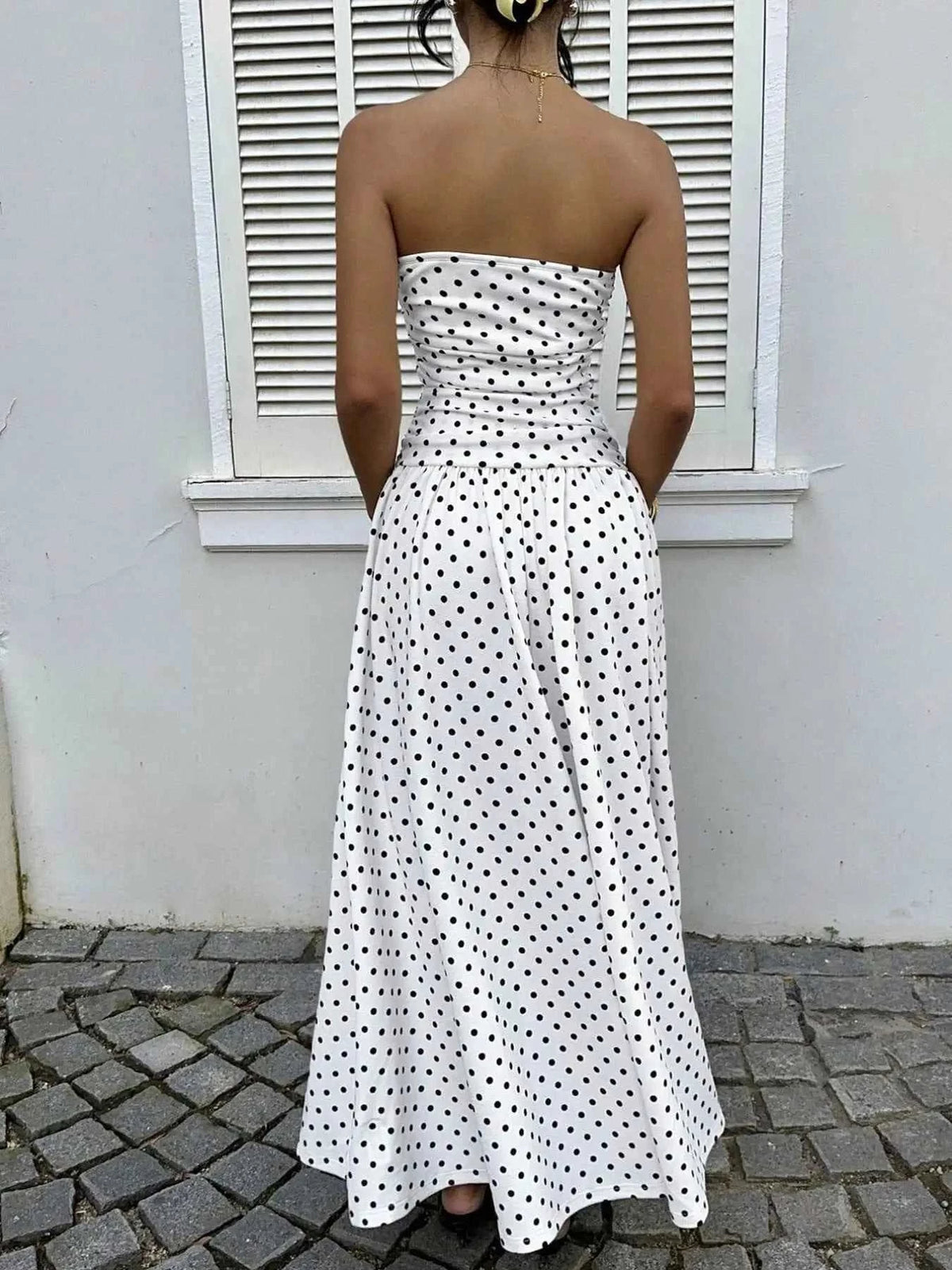 Polka Dot Ruched strapless white maxi dress with black polka dots, ruched bodice, and flowing skirt, made of polyester fabric