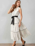Polka Dot Sleeveless Midi Shirt Dress in white with black polka dots, buttoned front, tiered skirt, and black belt at waist