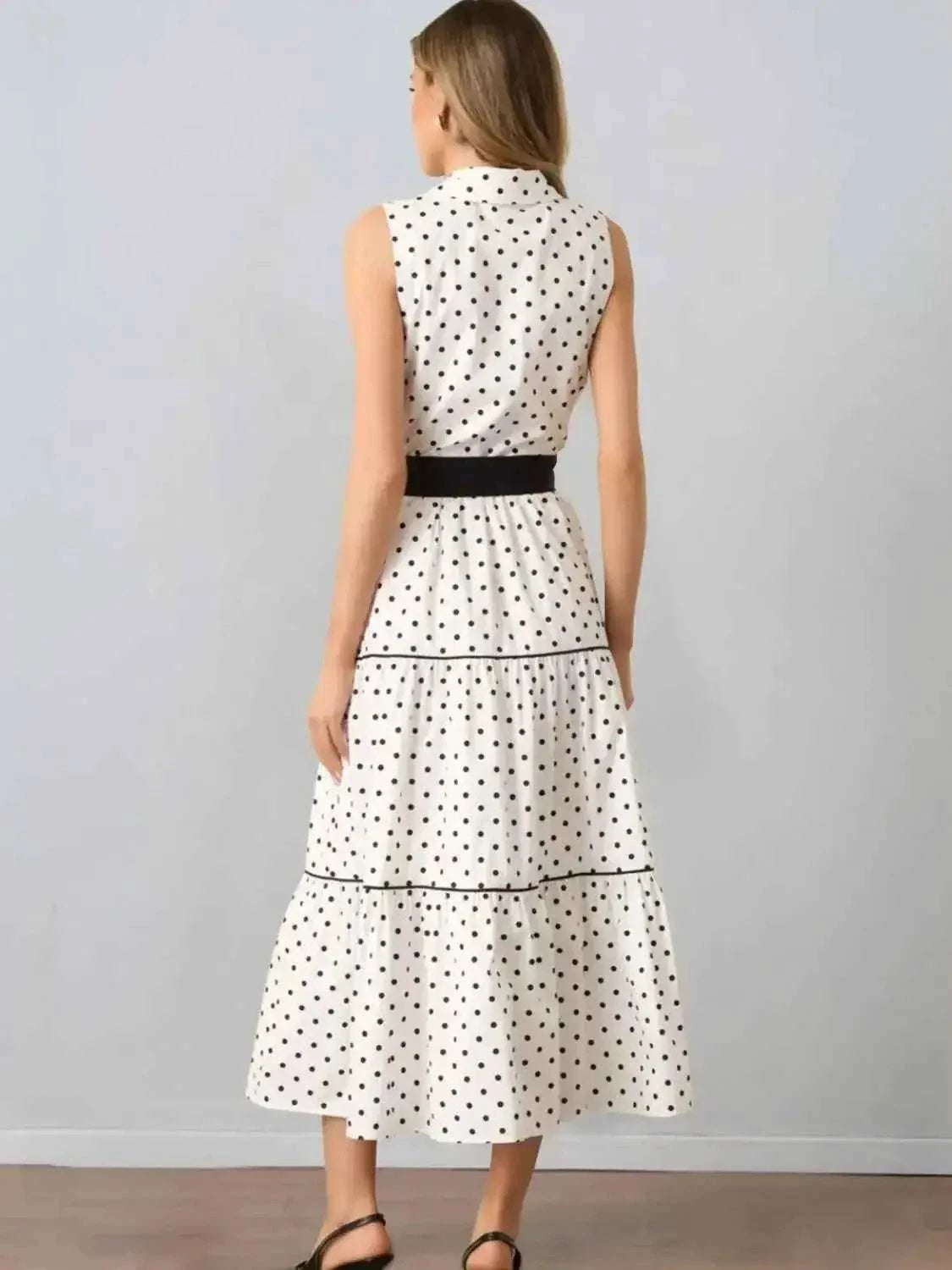 Polka Dot Sleeveless Midi Shirt Dress in white with black polka dots, tiered skirt, buttoned back, and black waist belt