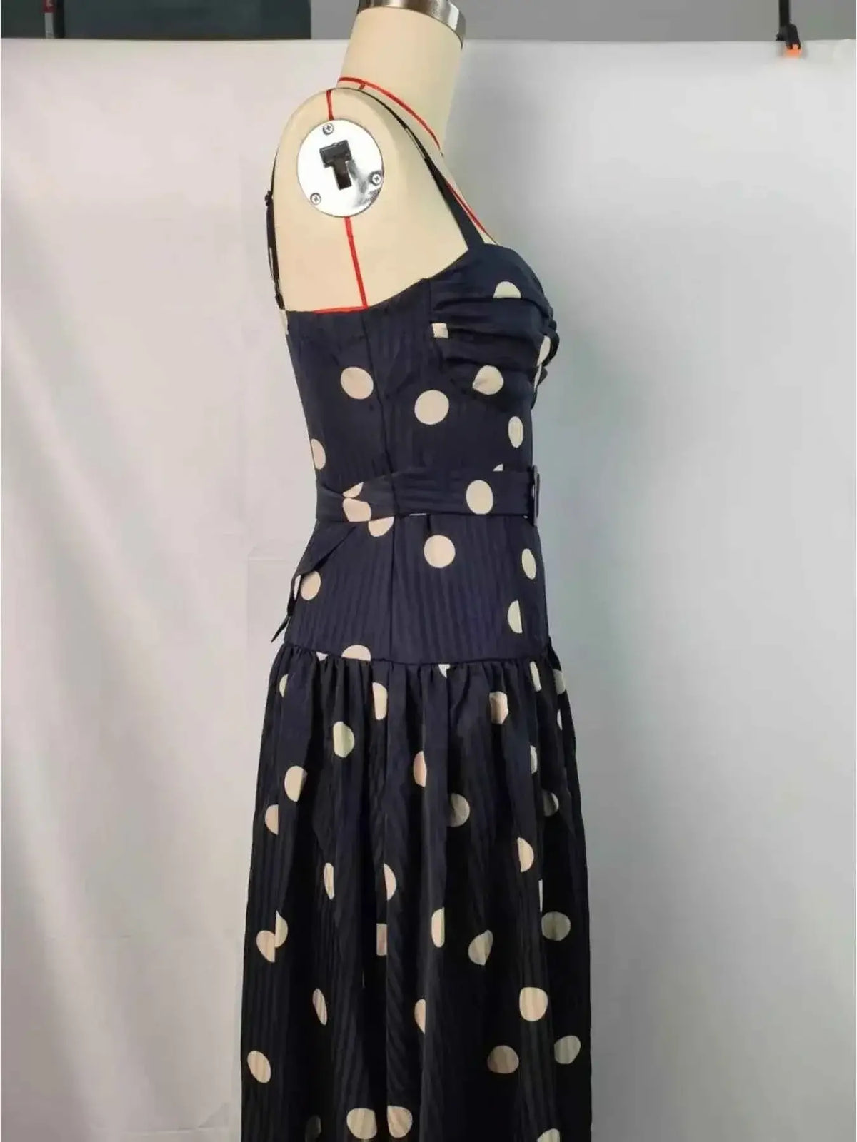 Polka Dot Sweetheart Neck Midi Dress featuring black fabric with large white polka dots, a fitted bodice, sweetheart neckline, and pleated skirt