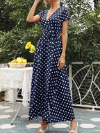 Polka Dot Wrap Maxi Dress in navy blue with white polka dots, short sleeves, V-neckline, belted waist, and flowy polyester fabric