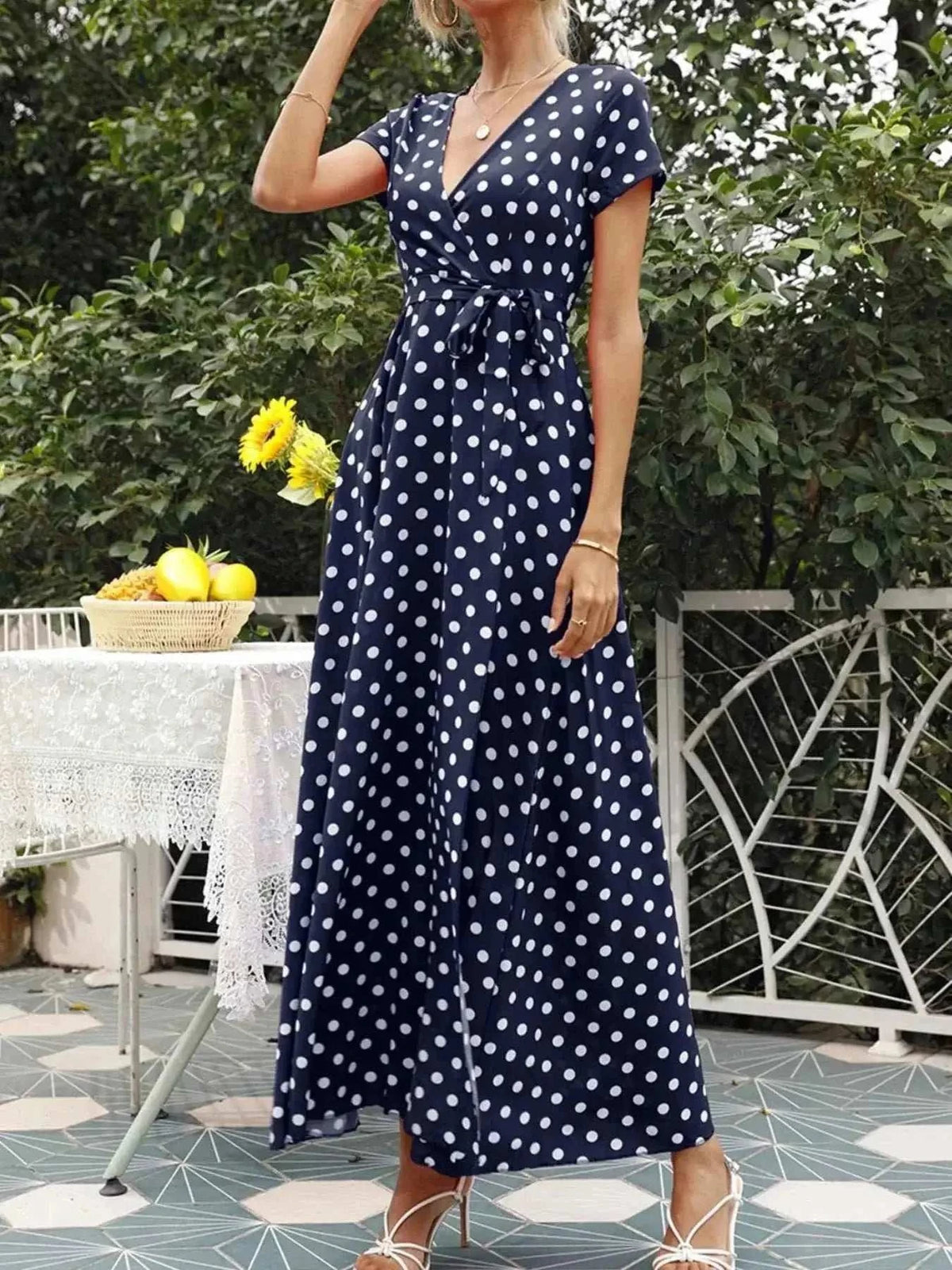 Polka Dot Wrap Maxi Dress in navy blue with white polka dots, short sleeves, V-neckline, belted waist, and flowy polyester fabric