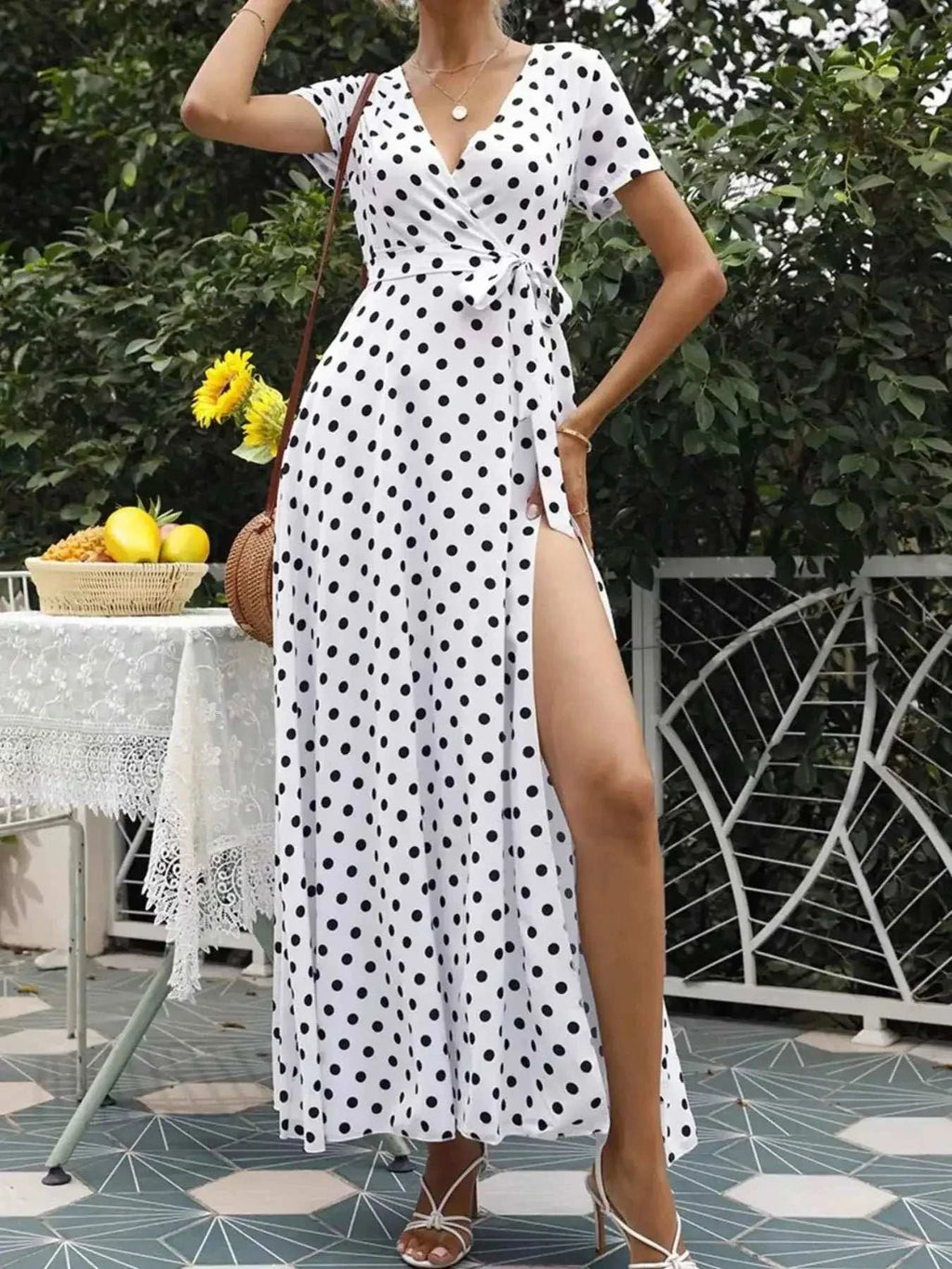 Polka Dot Wrap Maxi Dress in white polyester with black polka dots, belted waist, short sleeves, and a high slit