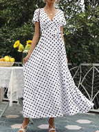 Polka Dot Wrap Maxi Dress in white with black polka dots, belted waist, short sleeves, and flowing maxi length