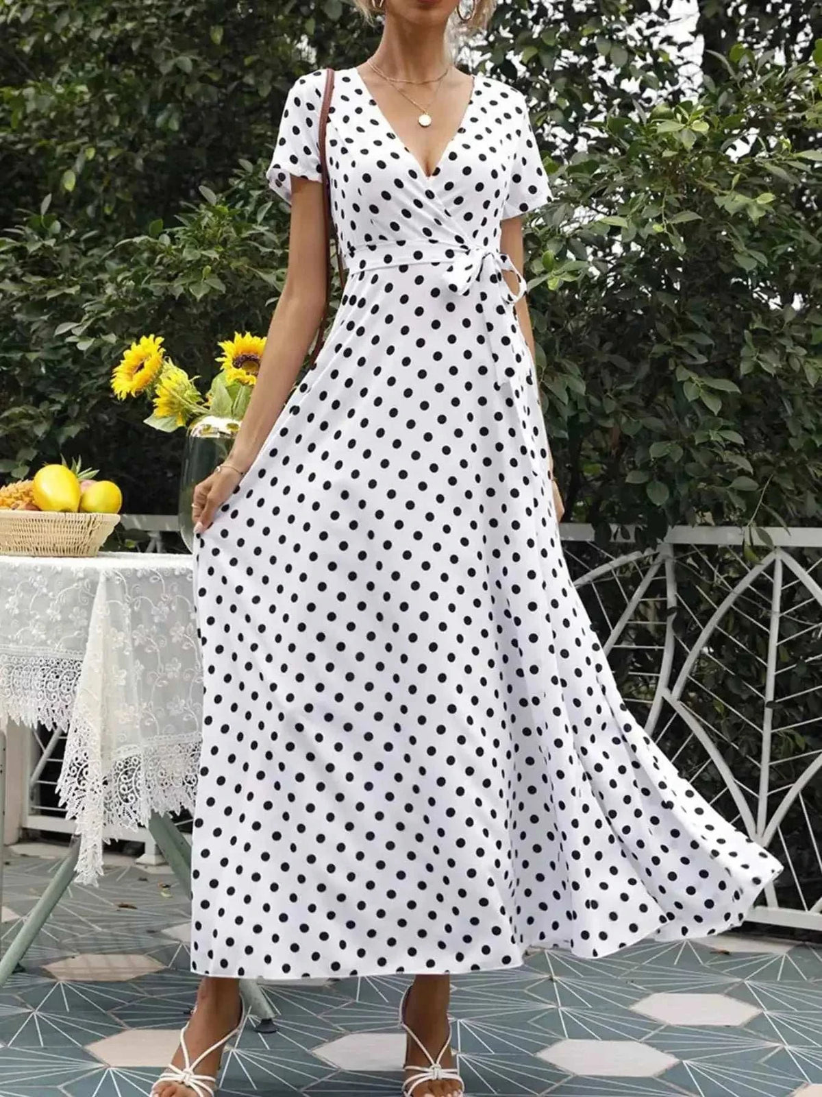 Polka Dot Wrap Maxi Dress in white with black polka dots, belted waist, short sleeves, and flowing maxi length