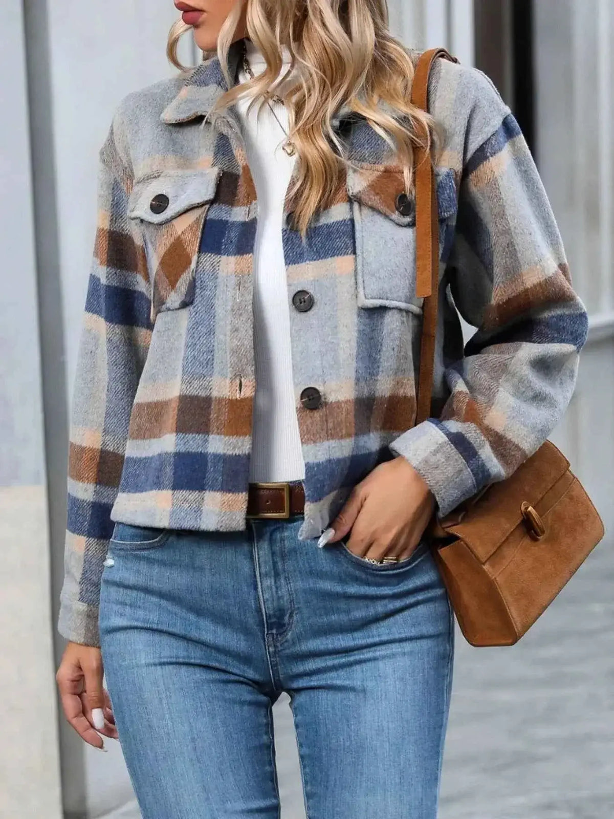 Polka Noir plaid button-up jacket in muted grey, brown, and blue tones with chest pockets, worn with blue jeans and brown bag