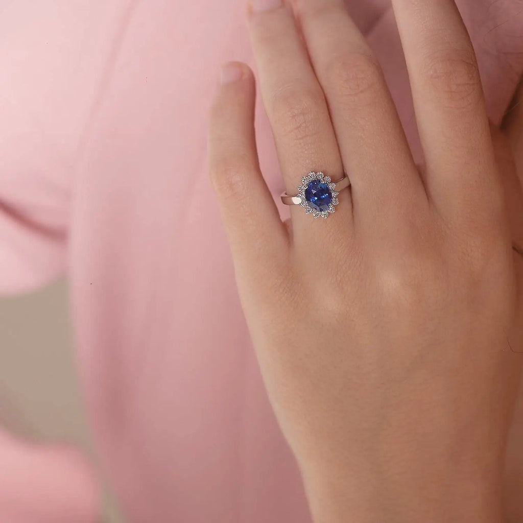 Princess Diana inspired 14K white gold ring with a deep blue oval sapphire center stone and a sparkling diamond halo