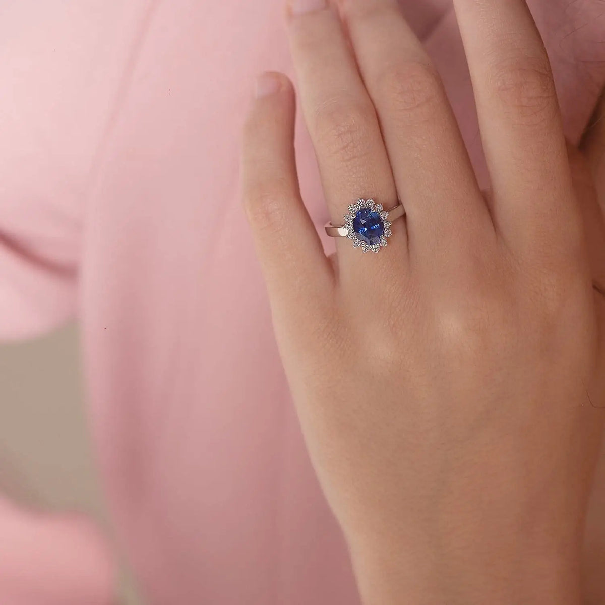 Princess Diana inspired 14K white gold ring with a deep blue oval sapphire center stone and a sparkling diamond halo