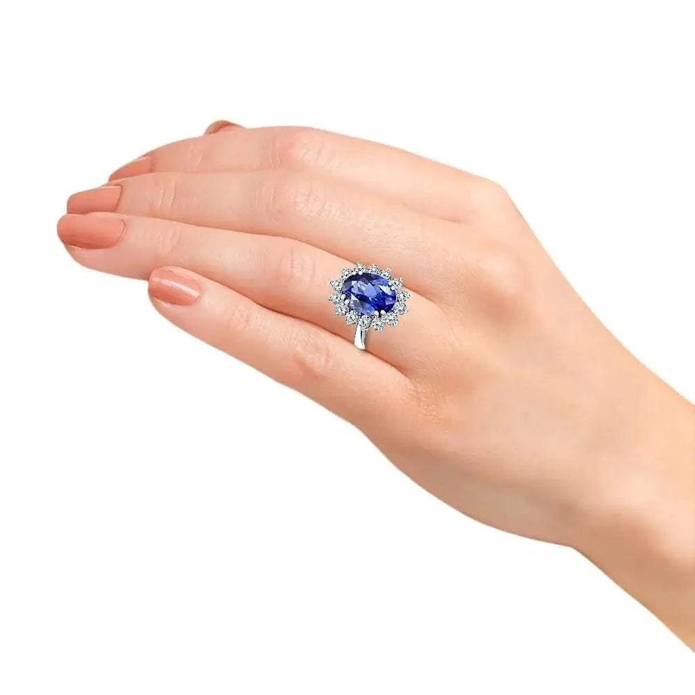 Princess Diana inspired 14K white gold ring with a large oval blue lab-grown sapphire surrounded by a halo of sparkling round diamonds