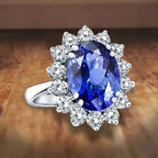 Princess Diana inspired 14K white gold ring featuring a deep blue oval lab-grown sapphire surrounded by a sparkling diamond halo