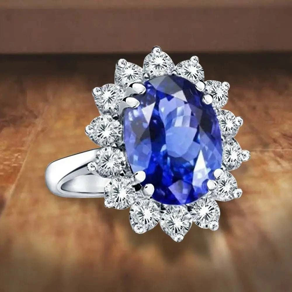 Princess Diana inspired 14K white gold ring featuring a deep blue oval lab-grown sapphire surrounded by a sparkling diamond halo