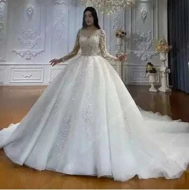 Regal Sparkle Ball Gown wedding dress with off-the-shoulder sheer long sleeves, intricate lace and sequin embroidery, and voluminous tulle skirt