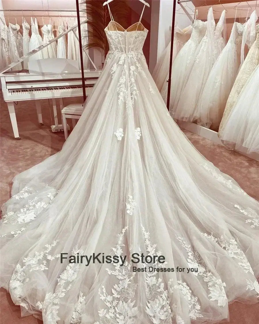 See-Through Wedding Dress in white featuring delicate spaghetti straps, floral lace appliques, a sweetheart neckline, and a flowing A-line skirt with train