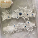 White bridal garter set with delicate Sexy Lace Flower lace embroidery and blue pearl embellishments on sheer fabric