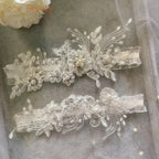 Two white polyester lace wedding garters featuring floral appliques with pearl and crystal accents, delicate Sexy Lace Flower design