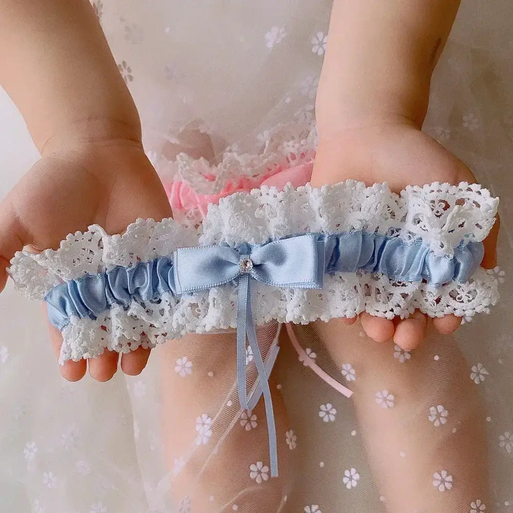 Wedding garter belt in white lace with blue satin ribbon and small bow adorned with crystal, featuring Sexy Lace Flower design