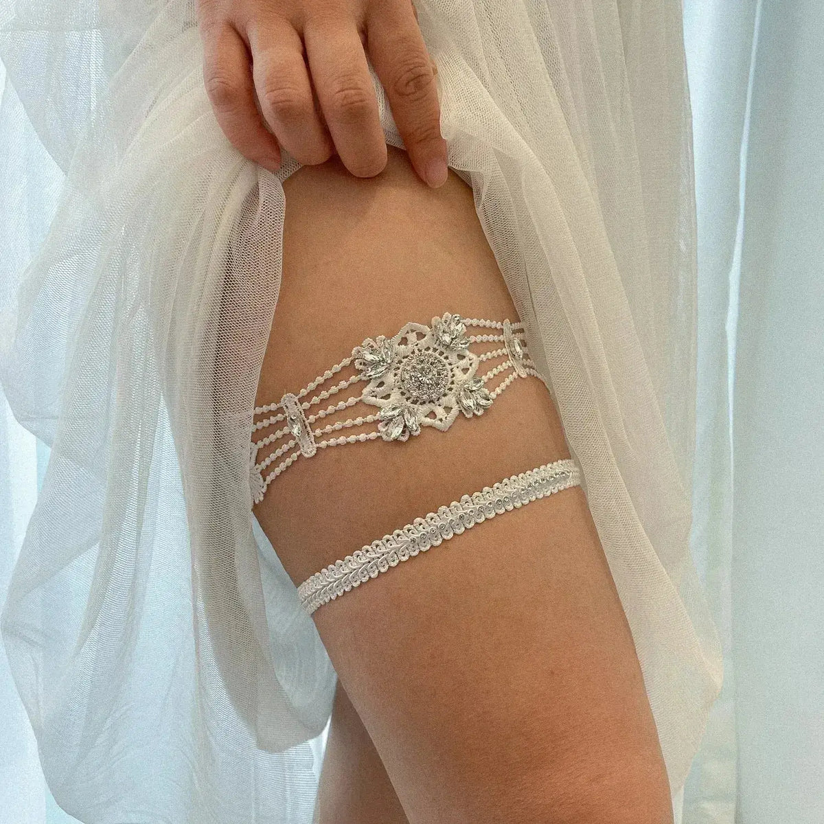 Sexy Lace Flower white lace bridal garter with crystal and pearl embellishments worn on thigh under sheer white fabric