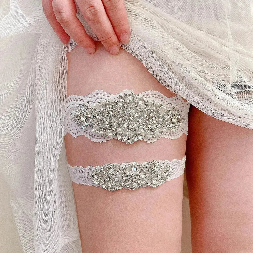 Wedding garter belts in white lace decorated with crystal pearls and floral appliques on a woman's thigh, Sexy Lace Flower design