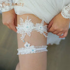 Sexy Lace Flower white lace wedding garter set with floral appliques and delicate crystal accents on woman thigh