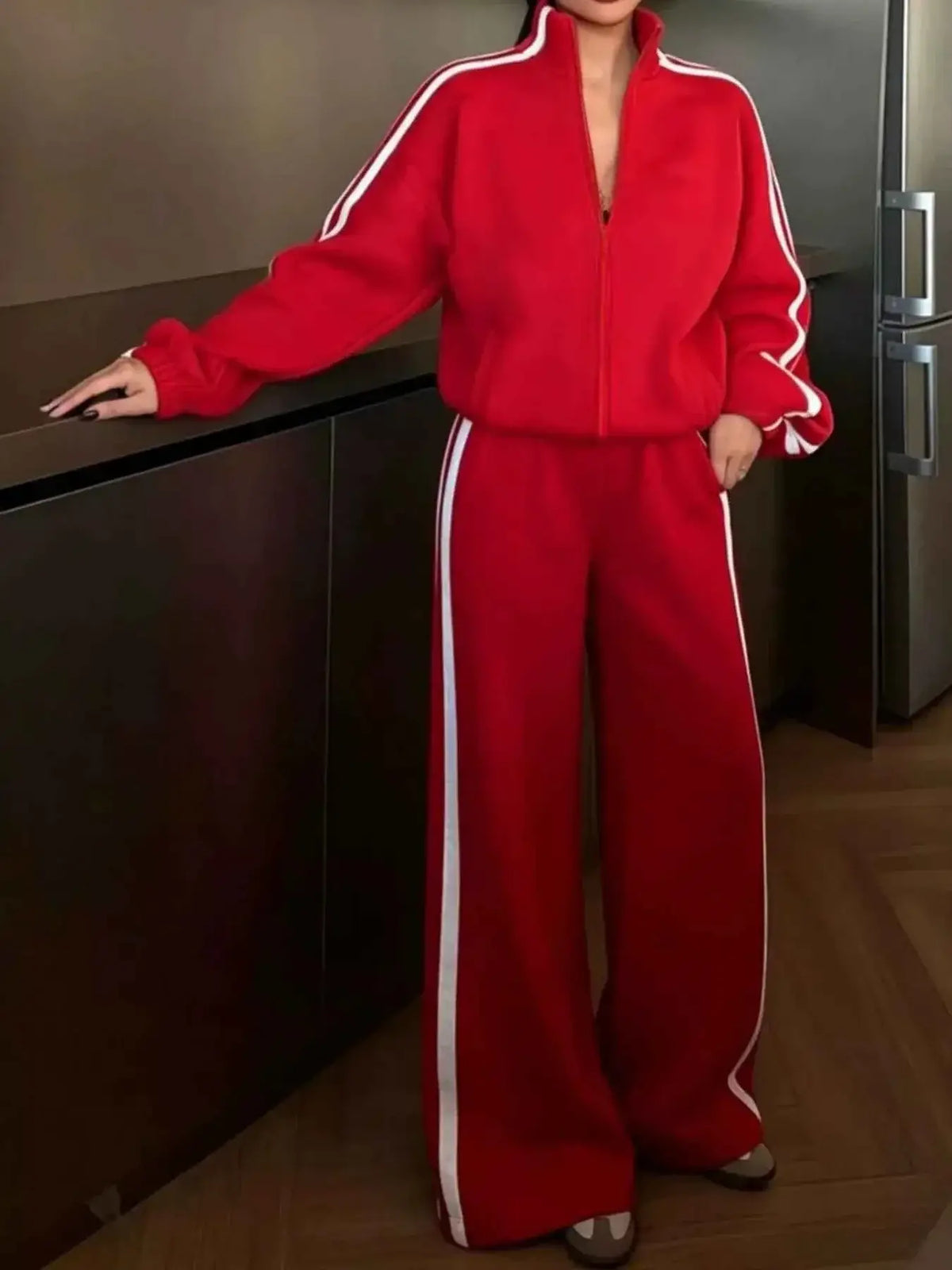 Red two-piece set with Side Stripes Zip Up Top and matching wide-leg pants featuring white side stripes and a zipper