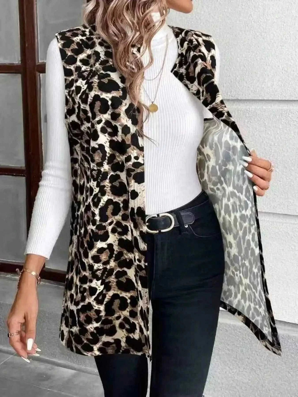 Sleeveless Leopard Print Vest in black and brown leopard pattern with side pockets worn over a white ribbed turtleneck and black jeans